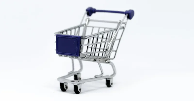 A modern miniature shopping cart on a clean white background, perfect for e-commerce concepts.