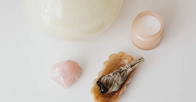 Serene flat lay of a candle, smudge stick, and crystal perfect for relaxation and spirituality.
