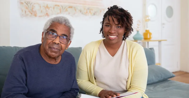 Caring moment between a senior man and a supportive woman at home, fostering connection and well-being.