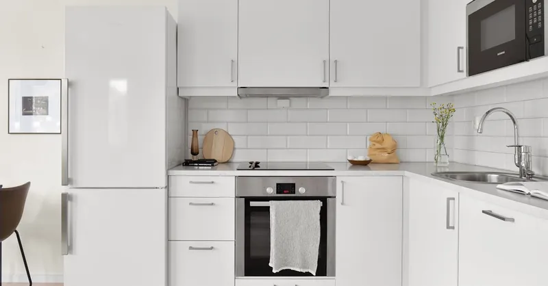 Sleek modern white kitchen featuring stylish appliances and minimalist design. Perfect for contemporary home inspiration.