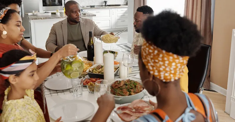 A joyous family gathering enjoying a meal together at home, highlighting togetherness and celebration.