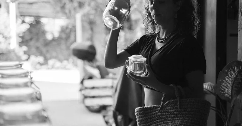 A woman holding glass jars in a thoughtful grayscale scene, evoking shopping and minimalism.