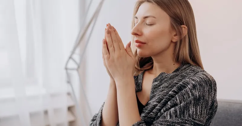 A serene woman practicing meditation indoors for relaxation and wellness.