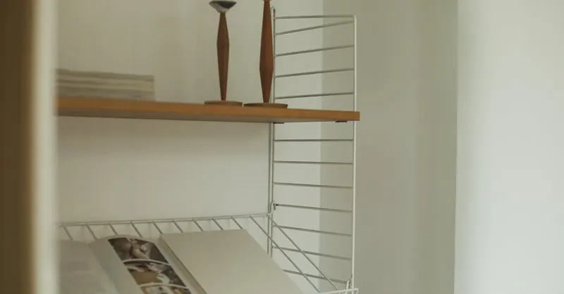 A minimalist bookshelf featuring an open book and elegant candleholders, perfect for modern decor inspiration.