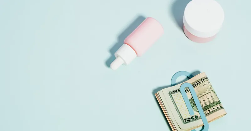 Stylish flat lay with skincare products and cash, ideal for beauty and finance themes.