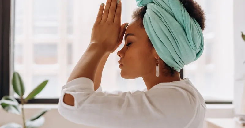 Woman practicing meditation indoors with a focus on relaxation and mindfulness.