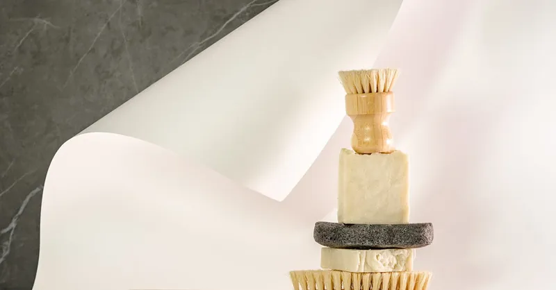 Artistic still life of eco-friendly cleaning tools and soaps in neutral tones.