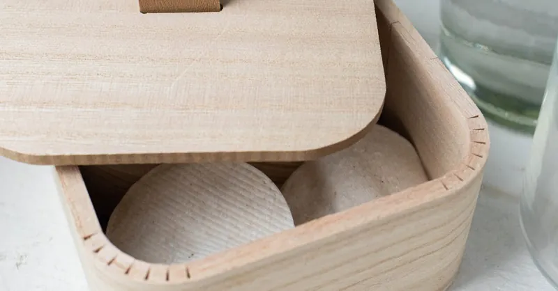 Minimalist wooden container holding eco-friendly cotton pads, ideal for sustainable living.