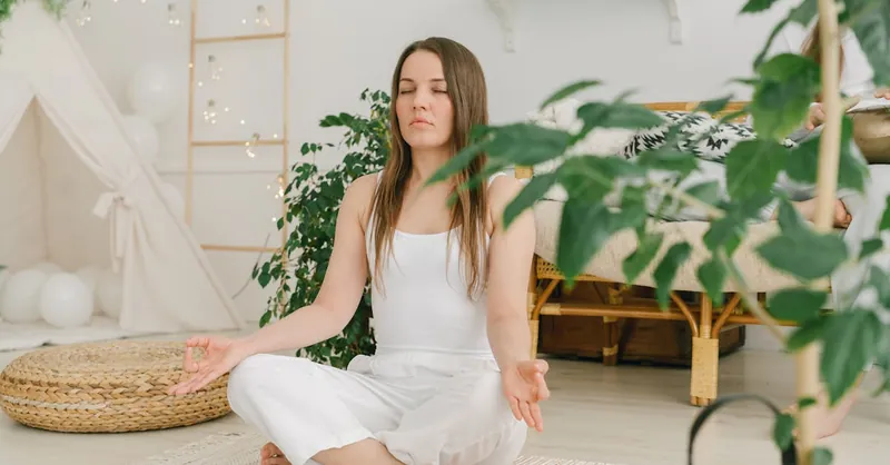 Peaceful meditation scene with a woman practicing mindfulness in a cozy, plant-filled indoor space.
