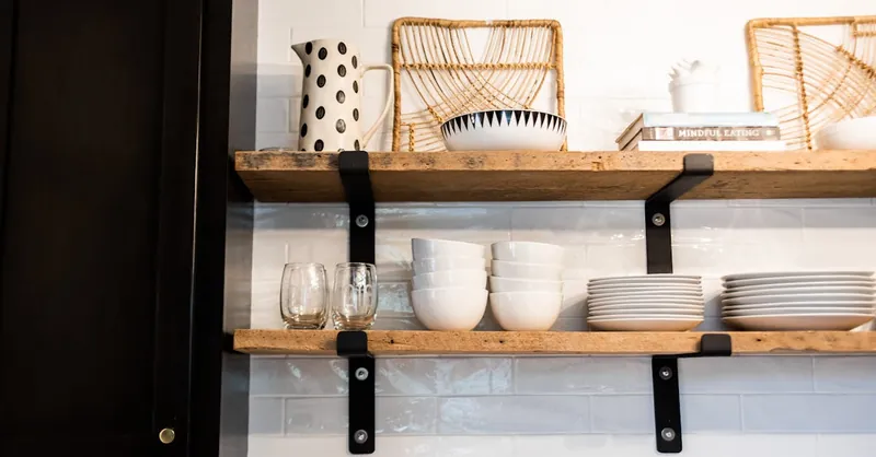 Sleek kitchen shelves featuring ceramic dishes, glassware, and wicker decor.