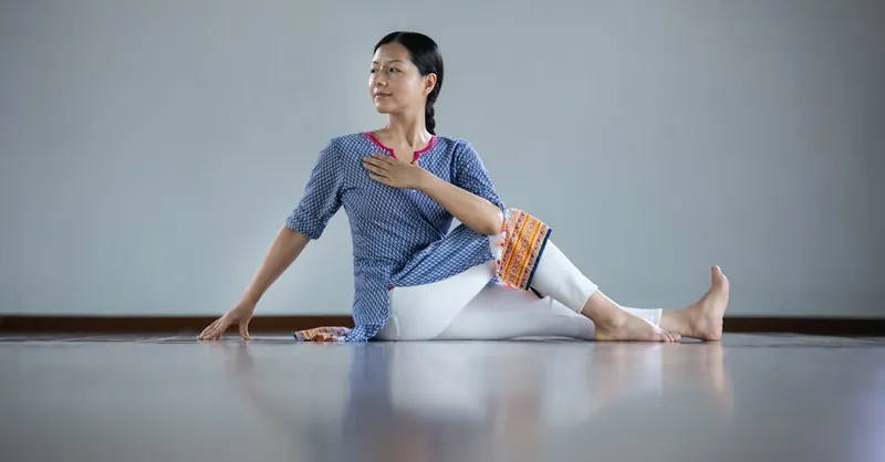 Woman performing a yoga stretch indoors, showcasing flexibility and tranquility.